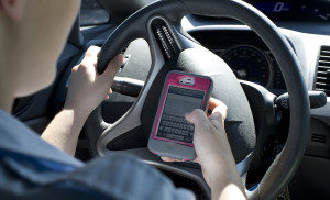 An Airman simulates texting and driving. Cell phone usage while driving is prohibited on Department of Defense installations. (U.S. Air Force photo/Airman 1st Class Nigel Sandridge)